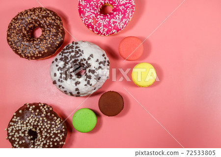 Tasty donuts and macaroons on pink background. Top view 72533805