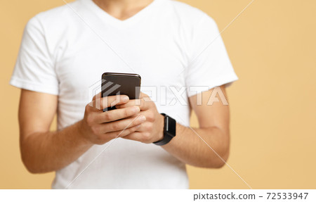 Social networks, blogs and mobile app. Smiling student watch in glasses hold modern phone 72533947