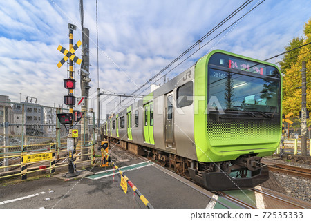 [Komagome, Tokyo] An e235 series vehicle on the Yamanote Line that passes in front of the barrier at the Daini Nakazato Railroad. 72535333