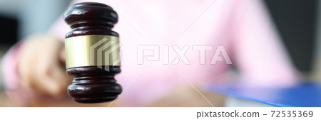 Female hand holds a wooden gavel for judges. Female hand holds a wooden gavel for judges. 72535369