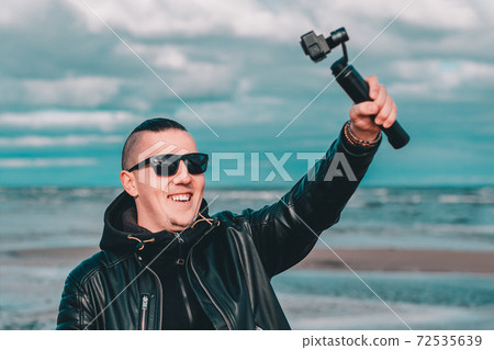 Young Male Hipster Making Selfie Using Action Camera Young Male Hipster Making Selfie Using Action Camera 72535639