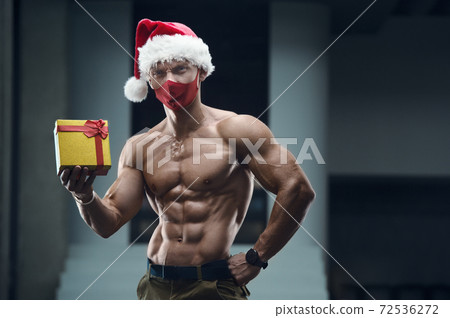 Fitness man in Santa Claus hat costume in gym Fitness man in Santa Claus hat costume in gym 72536272
