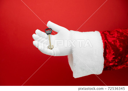 Santa Claus hand holds house key. Success, happiness, dream, december, mortgage, ownership, property, purchase, real estate, rent, sale, sell, accommodation, apartment concept. Santa Claus hand holds house key. Success, happiness, dream, december, mortgage, ownership, property, purchase, real estate, rent, sale, sell, accommodation, apartment concept. 72536345