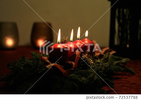 close up of an Advent arrangement with four burning candles close up of an Advent arrangement with four burning candles 72537788