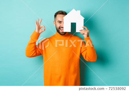 Real estate concept. Satisfied man recommending agency, showing okay sign and house maket, standing over blue background Real estate concept. Satisfied man recommending agency, showing okay sign and house maket, standing over blue background 72538092