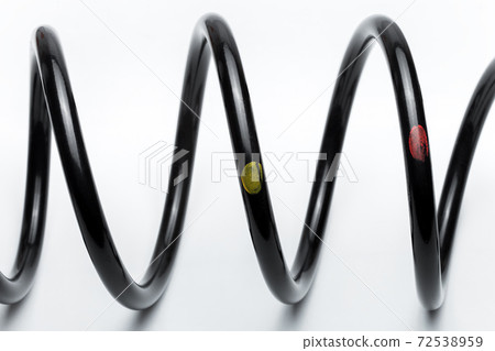 black coil spring made of durable steel for car suspension close-up replaceable spare part on white background, nobody. black coil spring made of durable steel for car suspension close-up replaceable spare part on white background, nobody. 72538959