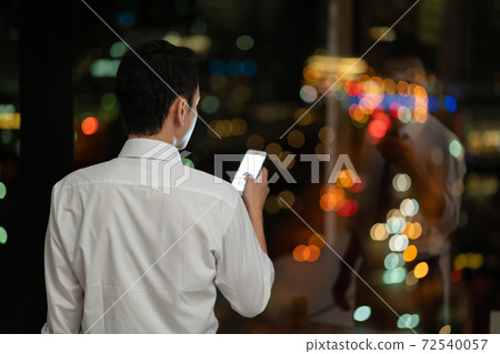 A businessman who works overtime late at night in the office 72540057