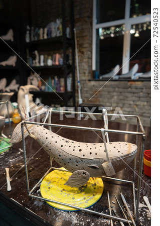 Clay whale on a stand in a pottery workshop 72540523
