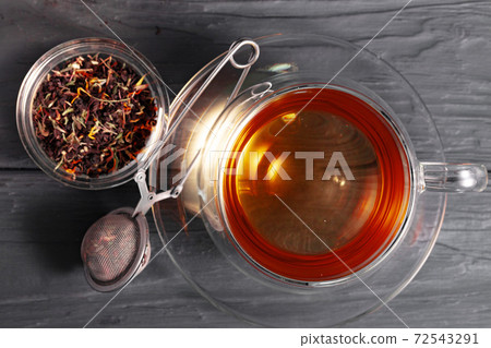 Glass cup of tea on wooden board Glass cup of tea on wooden board 72543291
