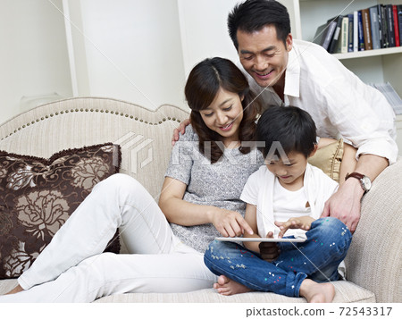 mother, father and son looking at tablet computer mother, father and son looking at tablet computer 72543317