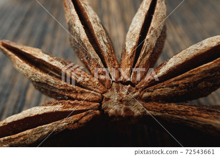 Macro photo of anise stars on wooden background Macro photo of anise stars on wooden background 72543661