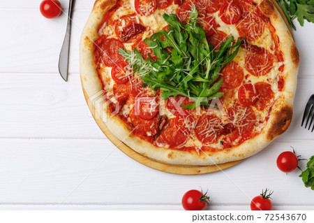 Pepperoni pizza on board on white wooden table Pepperoni pizza on board on white wooden table 72543670