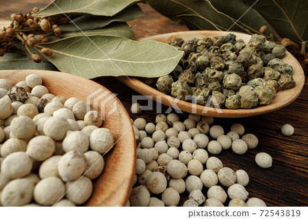White peppercorn spice heap on wooden table 72543819