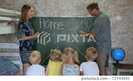 Home school concept. Parents give children a math lesson at the blackboard. Home school concept. Parents give children a math lesson at the blackboard. 72544695