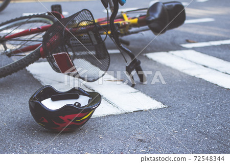 Helmet and bike lying on the road on a pedestrian crossing, after accident 72548344
