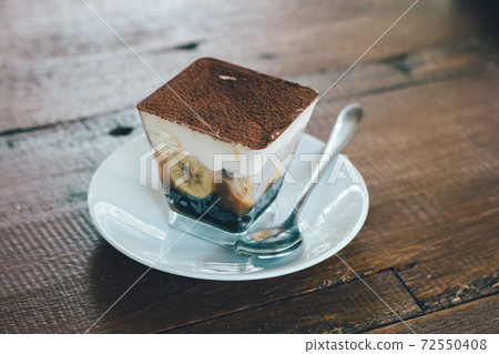 Close up view of Banoffee pie on the plate with wooden table. 72550408