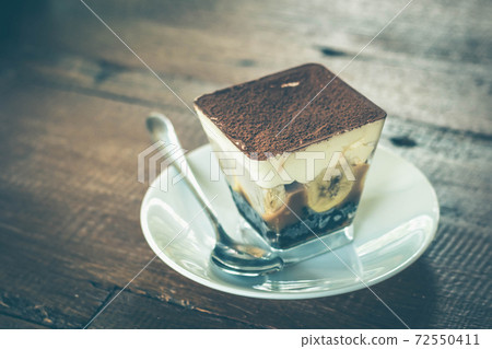 Close up view of Banoffee pie on the plate with wooden table. 72550411