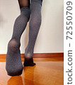 Legs of a woman standing in tights on the floor 72550709