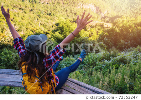 Young woman Tourists with backpacks Happy to travel She raised her hands and enjoying nature landscape view. 72552247