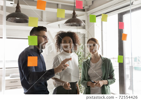 Multiracial colleagues develop ideas in office together Multiracial colleagues develop ideas in office together 72554426