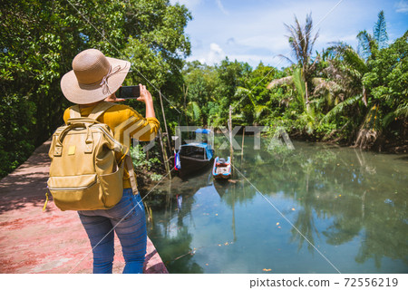 Asian woman travel nature. Travel relax. Using Mobile phone Take a boat photo beautiful nature at tha pom-klong-song-nam. Krabi, Travel Thailand. Asian woman travel nature. Travel relax. Using Mobile phone Take a boat photo beautiful nature at tha pom-klong-song-nam. Krabi, Travel Thailand. 72556219