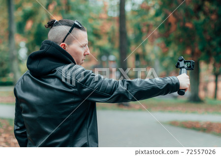 Handsome Male Blogger Making Video Using Action Camera 72557026