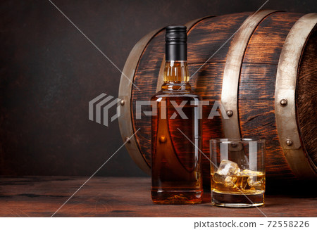 Scotch whiskey bottle, glass and old barrel 72558226