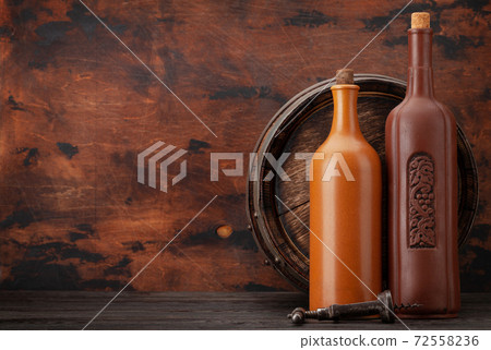 Wine bottles and old wooden barrel 72558236