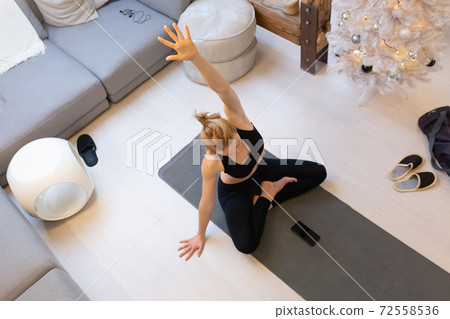 Beautiful blonde woman doing home workout indoors. Woman practice yoga at home. Fit girl using workout tutorials for healthy active lifestyle. Woman using quarantine for home workouts. Beautiful blonde woman doing home workout indoors. Woman practice yoga at home. Fit girl using workout tutorials for healthy active lifestyle. Woman using quarantine for home workouts. 72558536