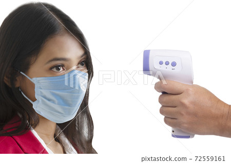 Woman was being measured body temperature with electronic handheld thermometer. Woman was being measured body temperature with electronic handheld thermometer. 72559161