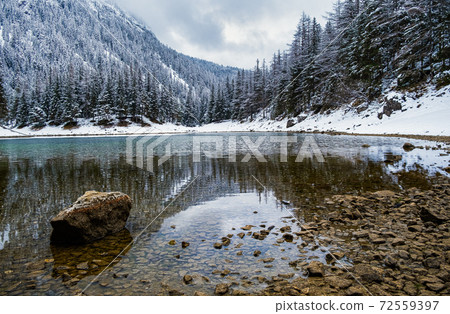 Green lake Gruner see cloudy winter day. Famous tourist destination. 72559397