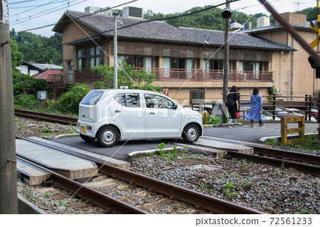 Light car passing through a railroad crossing 72561233