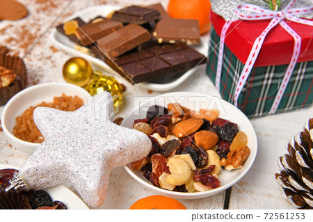 sweet food top view background for merry christmas or new year holiday decoration - chocolate candies, tangerines, cookies on white wood 72561253