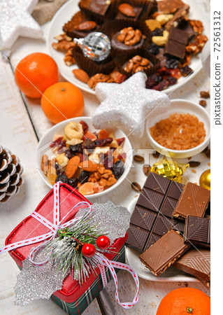 sweet food top view background for merry christmas or new year holiday decoration - chocolate candies, tangerines, cookies on white wood 72561312