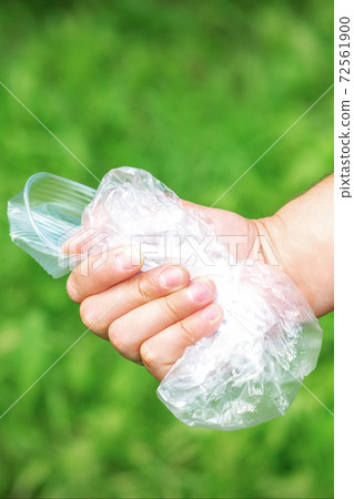 Hand holds crumpled plastic debris Hand holds crumpled plastic debris 72561900