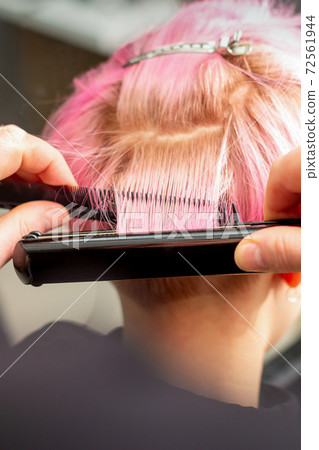 Hairdresser straightening short pink hair 72561944