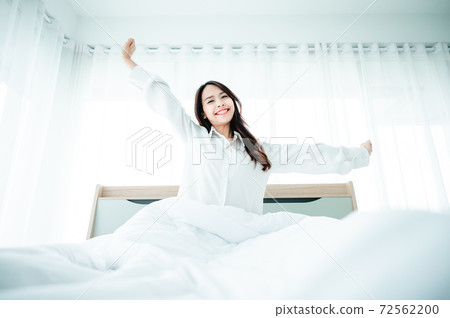 Beautiful women asian wake up in morning in bedroom. She is stretching and feeling fresh 72562200