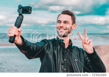 Handsome Guy Making Selfie at the Beach Handsome Guy Making Selfie at the Beach 72562880