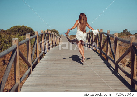 Beautiful woman is running on the bridge Beautiful woman is running on the bridge 72563340