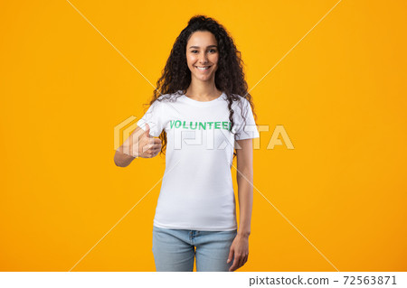 Cheerful Volunteer Lady Gesturing Thumbs Up Standing Over Yellow Background 72563871