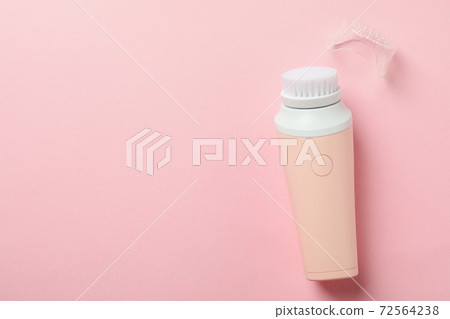 Electric massager with brush on pink background 72564238