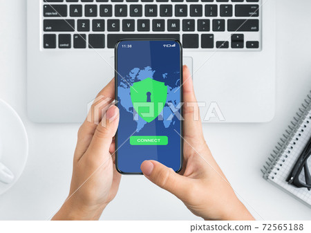 Female hands holding smartphone with vpn app on the screen, top view Female hands holding smartphone with vpn app on the screen, top view 72565188
