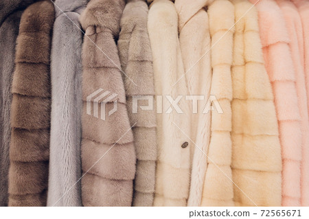 Luxury mink coats. Grey, brown, pearl color fur coats on showcase of market. Best gift for women is mink coat. Outerwear. Close up. Luxury mink coats. Grey, brown, pearl color fur coats on showcase of market. Best gift for women is mink coat. Outerwear. Close up. 72565671