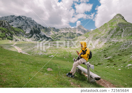 man travel with dog using smartphone at countryside with mountains scenic view man travel with dog using smartphone at countryside with mountains scenic view 72565684