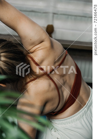 Back view of young woman in sportswear sitting in lotus position while doing yoga at home. Exercises for Back, stretching, pilates, Best Back Workout Exercises To Build Muscle, 72566478