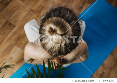Back view of young woman in sportswear sitting in lotus position while doing yoga at home. Exercises for Back, stretching, pilates, Best Back Workout Exercises To Build Muscle, 72566480
