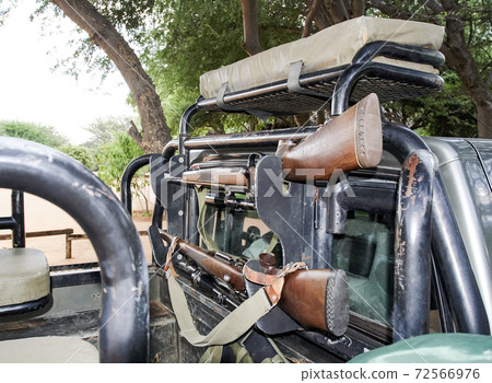 Fixing weapons in a hunting car during an African safari 72566976