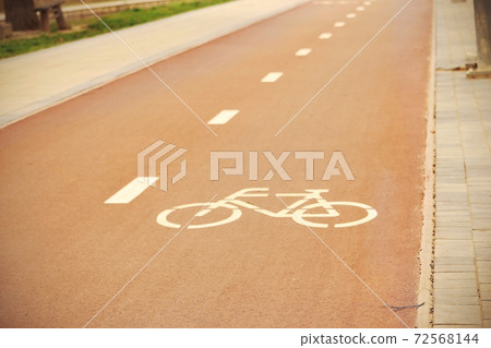 Downtown red bicycle track with painted sign 72568144
