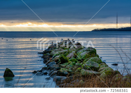 A beautiful sunset over the green boulders on a wave breaker. Photo from Hallevik, Blekinge, Sweden 72568381