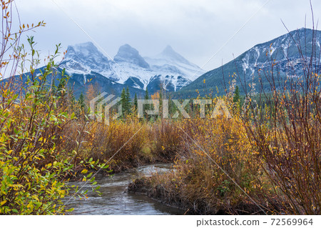 Snow capped The Three Sisters trio peaks mountain in autumn. Beautiful natural scenery landscape at Canmore, Canadian Rockies, Alberta, Canada. 72569964